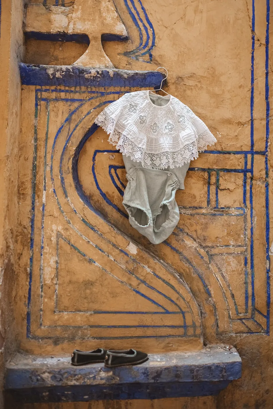 Cuello de puntilla y ranita colgados en una pared